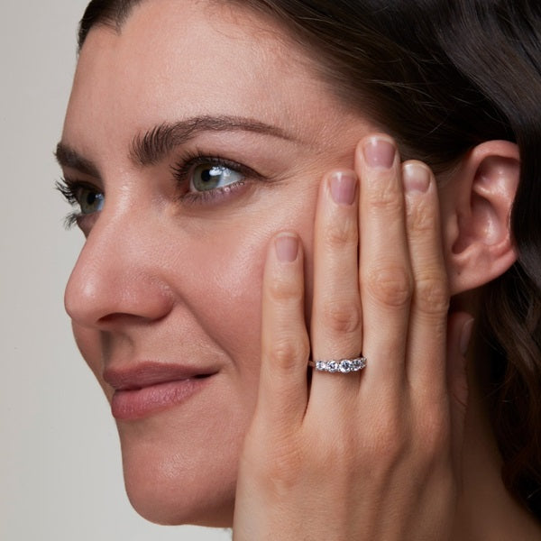 Woman wearing a moissanite 5-stone silver ring, showcasing its elegance and sparkle.