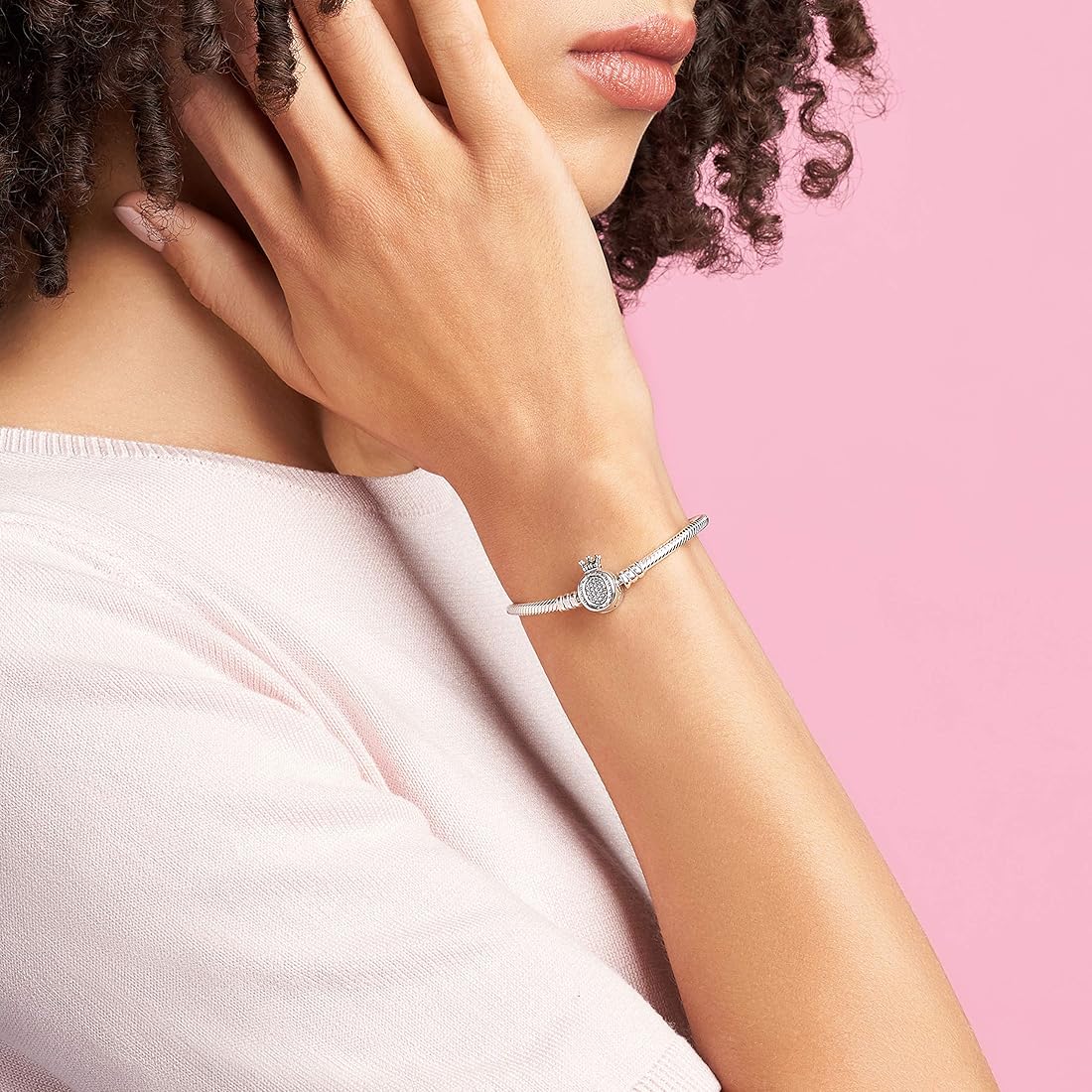 A close-up of the Silver Majesty Charm Bracelet on a model’s wrist, showcasing its crown motif and elegant silver finish.