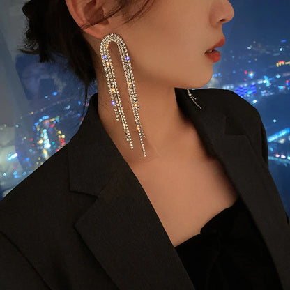 Model styling Starlight Fringe Drop Earrings with a chic evening outfit, highlighting their sparkle and sophistication.