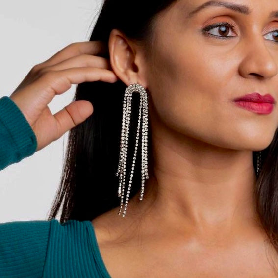 Woman wearing Starlight Fringe Drop Earrings in shimmering silver, adding an elegant touch to her outfit.