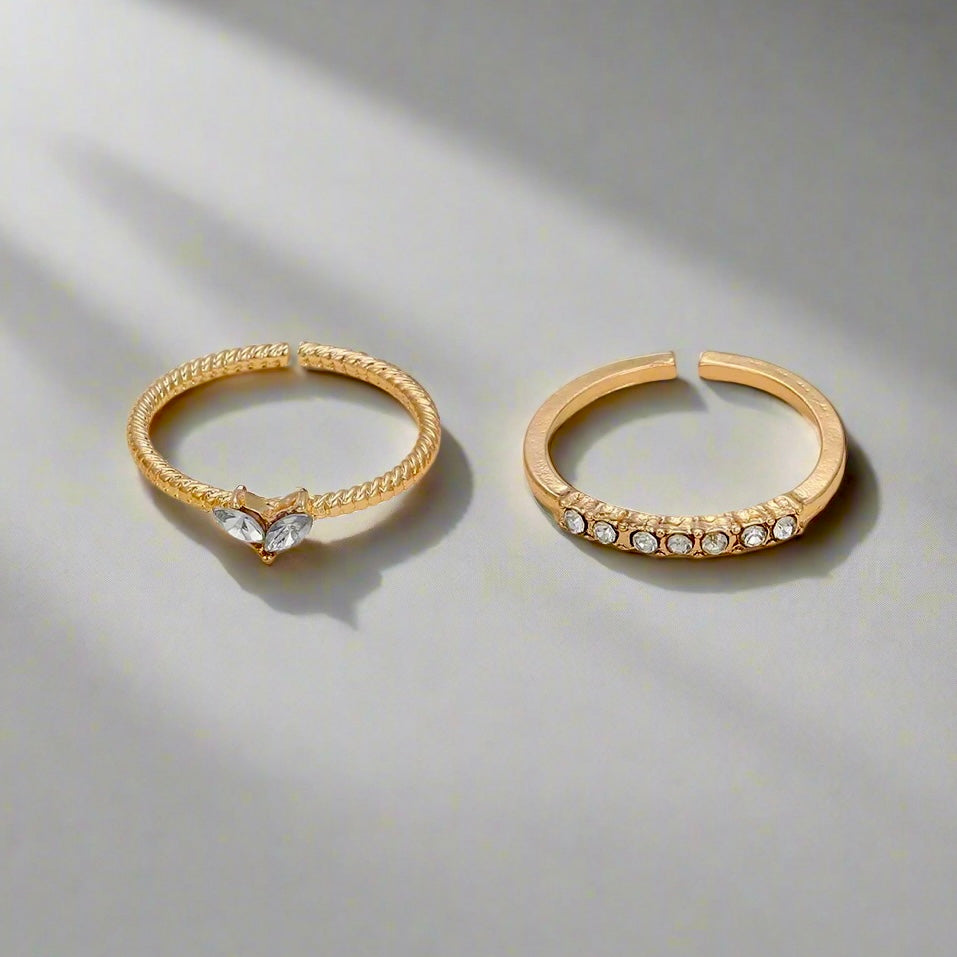 Gold and silver Stellar Embrace Rings displayed as a pair, symbolizing timeless elegance