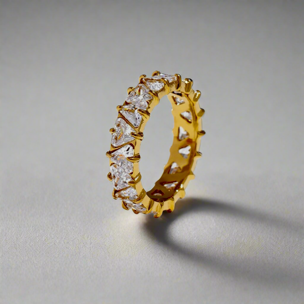 Stellar Eternity Ring in gold with a geometric crystal design displayed on a gray background.