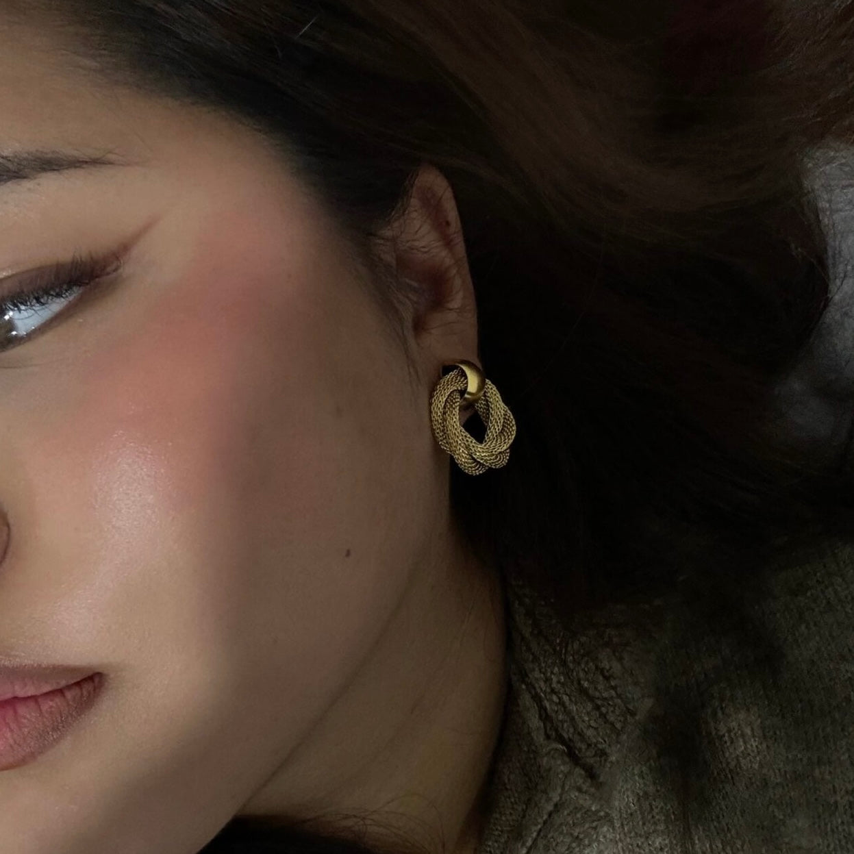 Side view of a woman wearing the golden Twisted Statement Earrings, highlighting their lightweight and stylish design.